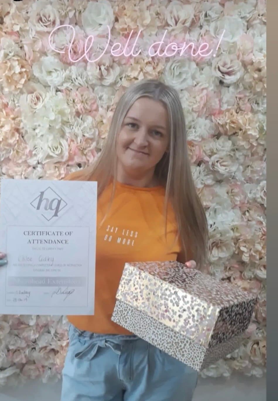 Student holding a certificate and kit